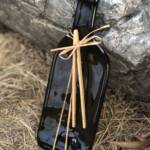 Cheeseboard made from wine bottle leans against rock